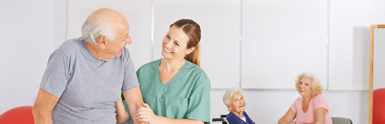 caregiver helping eldery man walk